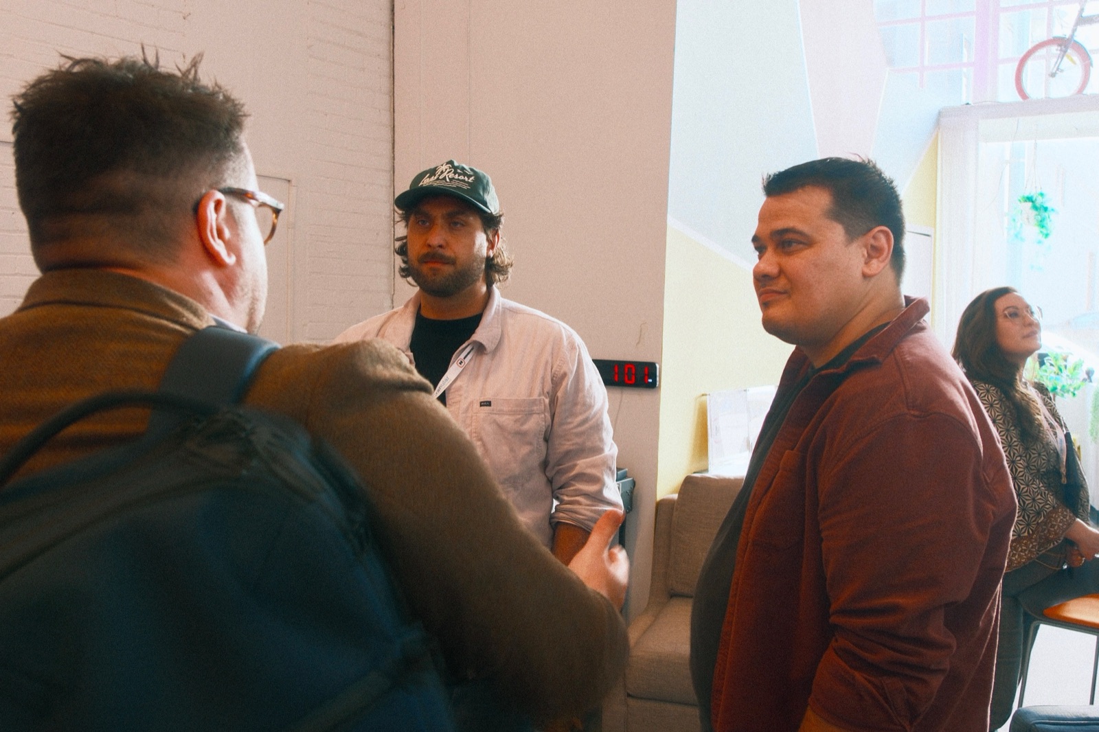 Tyler Einberger talks with MKE DMC attendees after the panel on AEO, GEO, and SEO at The Clubhouse, with panelist Renee Girard seated in the background